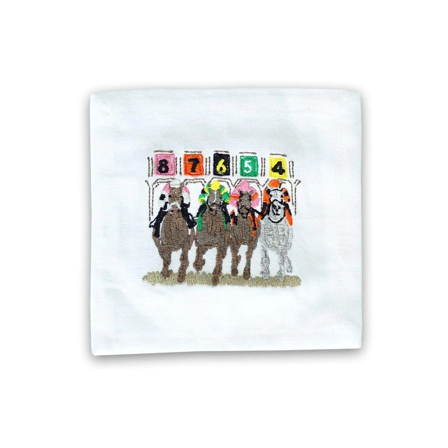This is a small white cocktail napkin with a colorful embroidered scene of Kentucky Derby horses leaving the paddock at the start of a race.